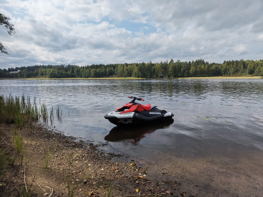 Vesijetti rannassa, taustalla metsäinen järvimaisema